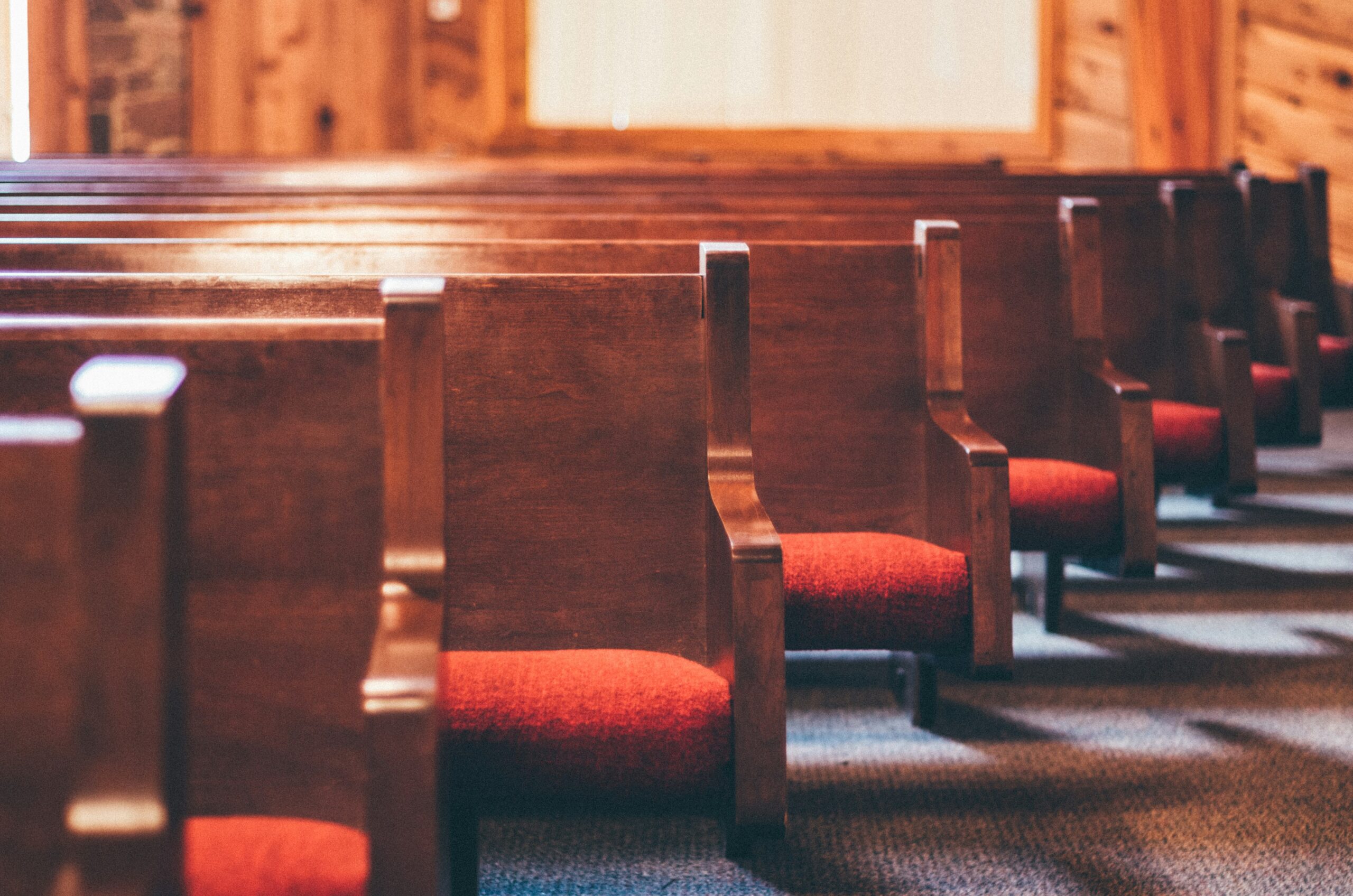 Empty wooden pews in a simple church sanctuary