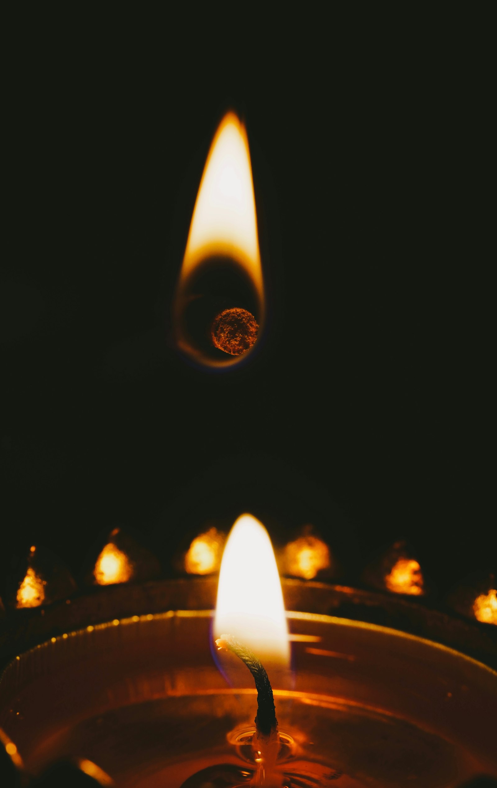 Close-up of oil lamp flames burning in darkness