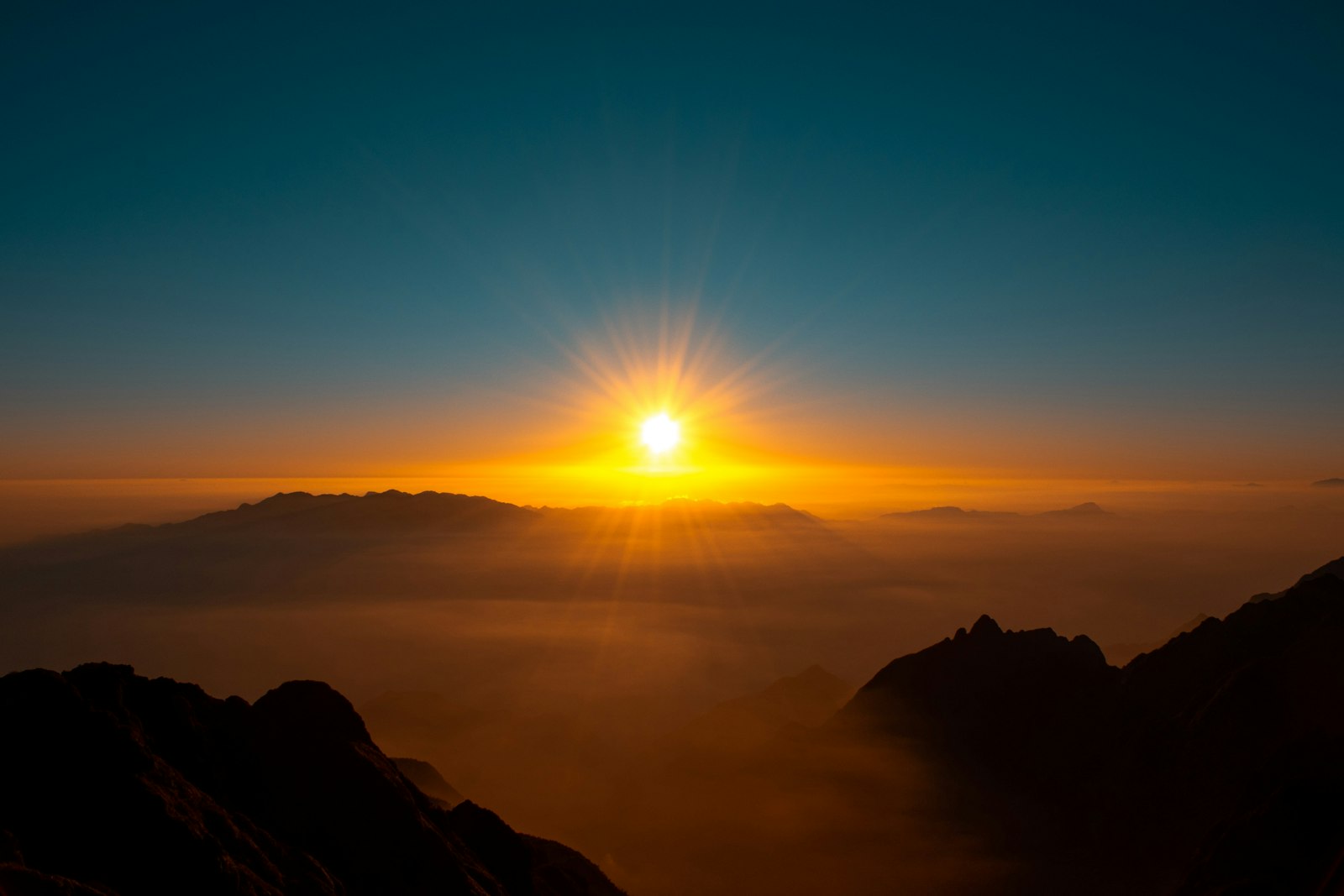 Sunlight breaking over mountain ridges at dawn